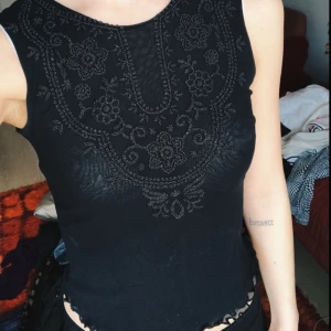  - Topp i mesh-material (ej genomskinlig) med pärlbrodyr över bröstet. Sparsamt använd.