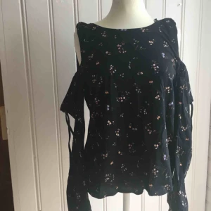  - Blommig topp med ”öppna axlar” Aldrig använd