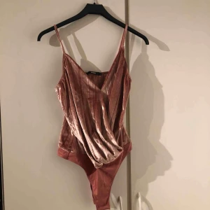  - En rosa body, helt ny. Storlek L men passar S.