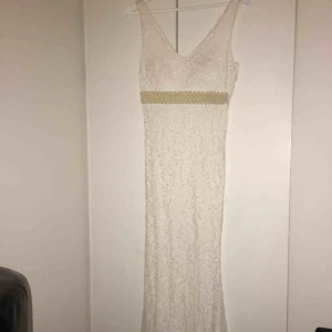  - Helt oanvänd med etiketten kvar. Den är i perfekt skikt. Fina mönster på den och en fin detalj med pärlor under brösten. Den är lång med en slim fit detalj där den sitter åt ner till vaderna. Kom privat för fler detaljer och bilder. Pris kan diskuteras