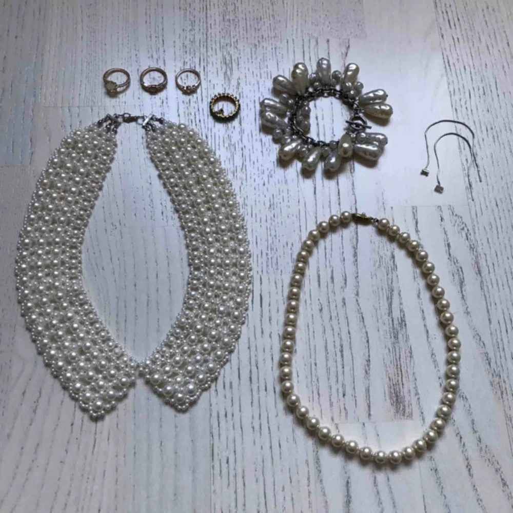 Paketpris för 8 smycken med konstgjorda pärlor: - pärlshalsband formad som en krage - Klassiskt pärlhalsband - Maffigt pärlarmband med stora pärlor - 4 guldmetallfärgade ringar - 1 par silverfärgade örhängen med en glaspärla.. Accessoarer.