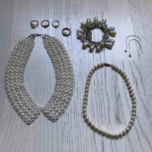 Paketpris för 8 smycken med konstgjorda pärlor: - pärlshalsband formad som en krage - Klassiskt pärlhalsband - Maffigt pärlarmband med stora pärlor - 4 guldmetallfärgade ringar - 1 par silverfärgade örhängen med en glaspärla.