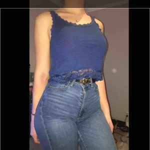  - Marinblått linne med spetsiga detaljer.