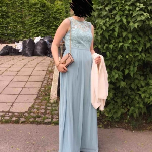 - Balklänning från märket Jane Norman London. Endast använd en gång och i superbra skick! Underbar himmelsblå färg och mönstrad överdel med små paljetter. Jag på bilden är ca 173 cm lång. Skriv gärna om du har frågor! 