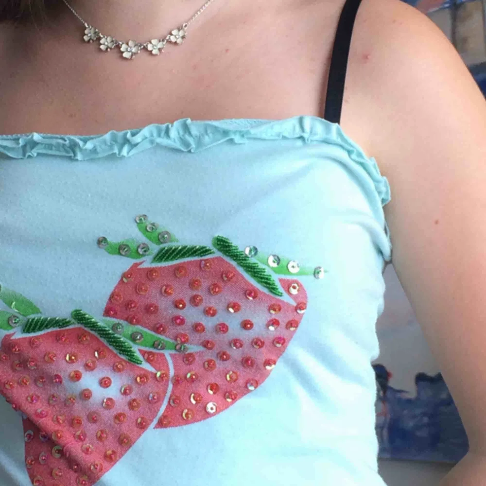 Blå TubTopp med två jordgubbar på framsidan. Detaljer i form av pärlor och paljetter. Supersöt!! Kika gärna på mina andra annonser:). Toppar.