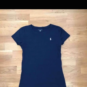  - Tröjan ser stor ut i bilden men är storlek 12-14 men passar mig med storlek xs. Marinblå med Ralph louren märket i ljus rosa. Väldigt fin och i bra skick!! Köparen står för frakten annars kan jag mötas upp i Stockholm.
