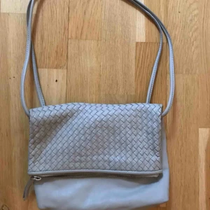  - Grå väska från COS. Fint skick i läder. Lätt och med dragkedja. Fin på sommaren!