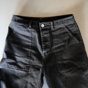 Grå byxor i storlek 30 - Ett par gråbyxor i snickarstil och robust tyg. Storleken är midjemått 30(tum) och längd 32(tum). Använda ett fåtal gånger och i nytt skick. Inga skador. Frakt 66kr