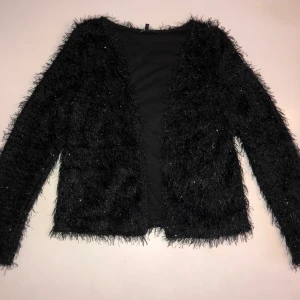 Glittrig cardigan från Vero Moda - En svart, glittrig kofta som är använd 1 gång. Storlek S. 