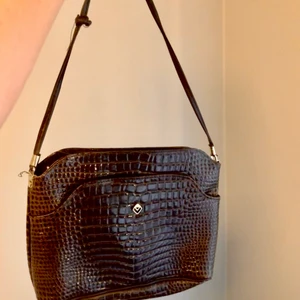 Handväska i ormskinn - Supertrendig axel/handväska i brunt ormskinn (inte äkta såklart), hade jättelånga band innan så klippte av och knöt istället, inte supersmart hehe (därav lite lägre pris) 