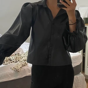 Skjorta PU-limitation  - Säljer denna fina PU-imitation skjorta (materialet är alltså inte PU utan mjukare). Den är tidigare köpt här på Plick men säljer då den var för liten för mig. Skulle säga att storleken är XS/S. Fint skick! (Frakt tillkommer) 