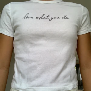 White t-shirt says love what you do -  the item has never been worn