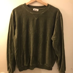 Mörkgrön tjocktröja - Mörkgrön tjocktröja av polyestermaterial från KWOSHARE i storlek medium