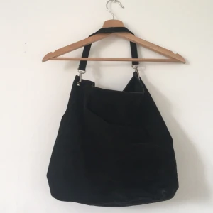 Mockaväska - Mockaväska i fakeläder köpt på 2hand. En väska som funkar med vilken outfit som helst. Rymlig med knapp för knäppning och fack för mobil, plånbok och ett med dragkedja. 