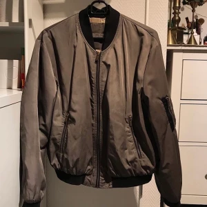 Bomberjacka - Bomberjacka i grön/brun nyans med svarta och guldiga detaljer 