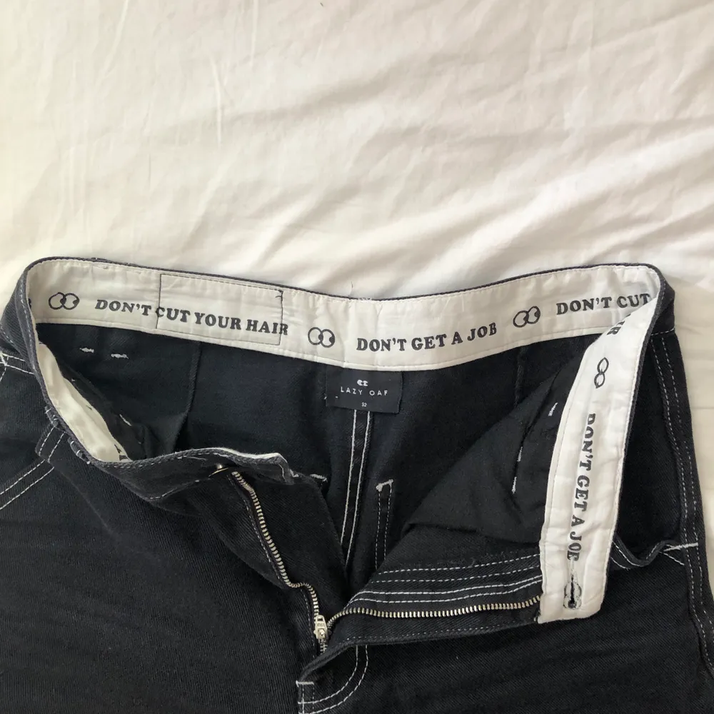 Ascoola svarta byxor i jeansmaterial från Lazy Oaf. Vita synliga sömmar med coolt broderi på baksidan av två smileys. Jag är 179 cm. Jeans & Byxor.