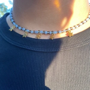 Pärlhalsband  - Svart och grått pärlhalsband med guldiga stjärnor!