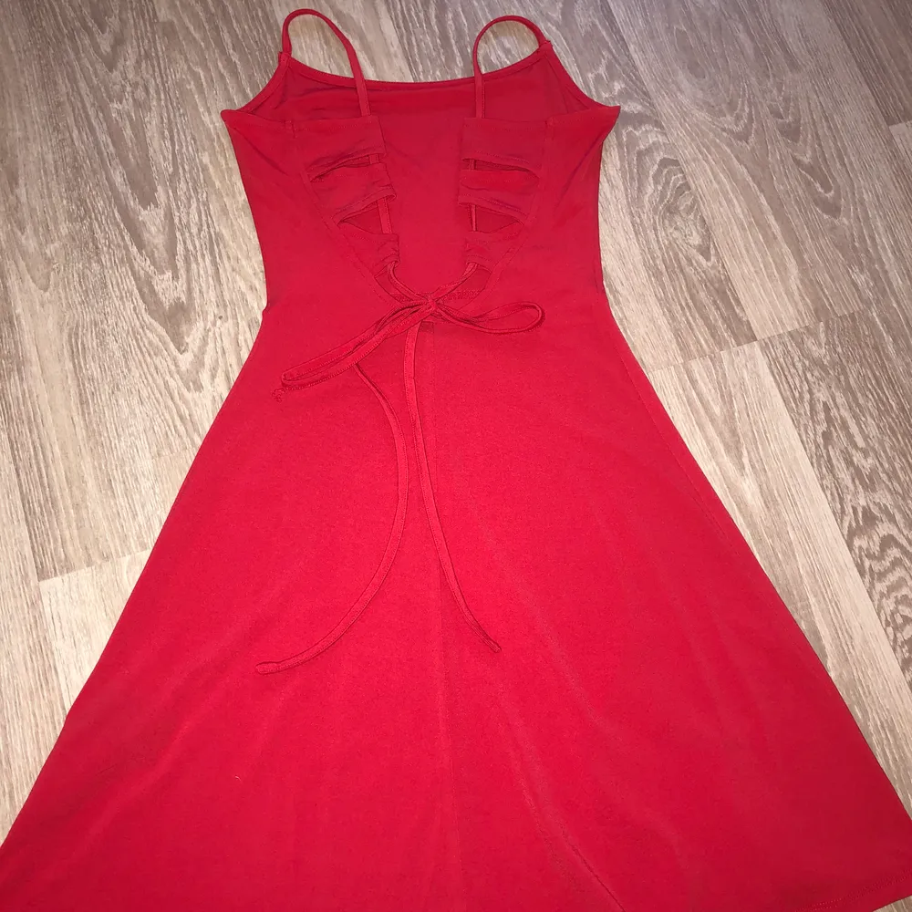 Röd klänning från H&M med öppen rygg och snörning. Strl 36, knappt använd. . Klänningar.