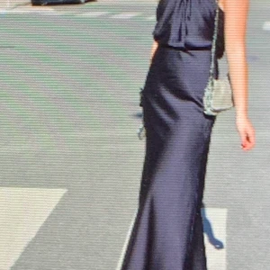 Blå klänning i sidensatin  - Lång mörkblå klänning med halterneck, super fin, använd en gång i nyskick. Köpt för 1000kr från Asos