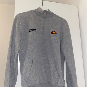 Ellesse sweatshirt strl: S - Grå sweatshirt från Ellesse, hög krage med dragkedja och stor ficka på magen. 
