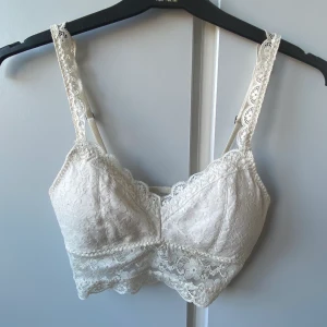 Bralette från Hollister  - Vit bralette i fin spets från Hollister, knappt använd. 50kr + 60kr frakt.
