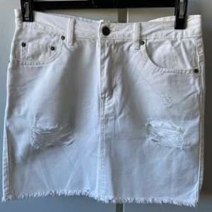 Jeanskjol från Nelly - Vit jeanskjol med slitningar från Nelly, strl s. Använd max 3 gånger, så i väldigt bra skick. 