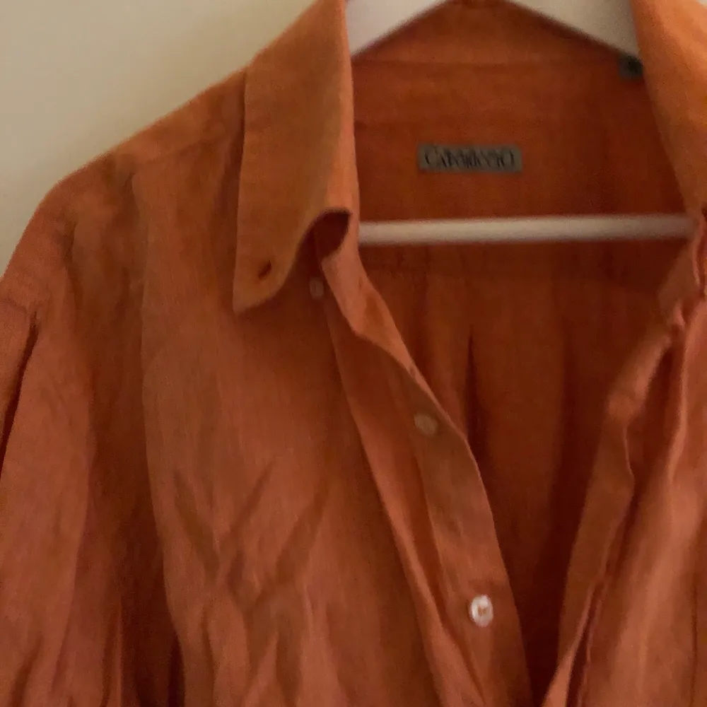 Orange skjorta i linne material. Inga hål eller fläckar men lite skrynklig. . Skjortor.