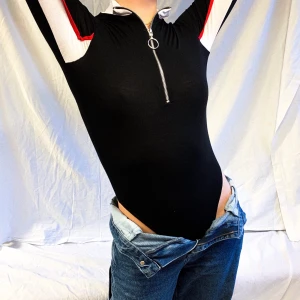 Y2K BODY I STRINGMODELL - Säljer denna asballa high rise bodyn med dragkedja eftersom den tyvärr aldrig kom till användning! Insidan av armarna är vita med röd detalj vilket ger en cool racer/biker vibe 🤩 Skicket är så gott som nytt och den stretchiga modellen passar XS-M! Buda privat eller i kommentarerna🤍 🏎