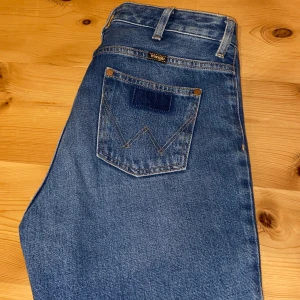 Wrangler jeans - Riktigt snygga och nästintill oanvända utsvängda jeans från wrangler som tyvärr är för små för mig, men lagom i längden och jag är 178. De har snygga detaljer nere på benen och unika fickor. Hör av dig vid frågor eller om du vill ha fler bilder!💕 