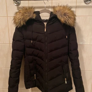 Fakepäls vinterjacka  - En härlig vinterjacka med fakepäls och världens största luva. Säljer denna goding då den inte kommer till användning längre. Inköpspris: 899kr. Inga synbara skador eller fläckar, forfarande fräsch och snygg. 
