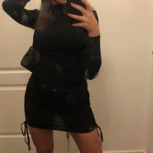 Svart tajt klänning ifrån ginatricot. - En svarr skön tajt klänning, man kan även bestämma hur kort och lång man vill klänningen ska vara med banden som sitter hängandes på bilderna. 