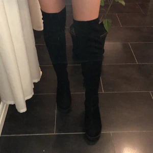 Svarta stövlar med klack, storlek 38 - Dessa stövlar är svarta i storlek 38 med en klack på ungefär 7 cm. Stövlarna slutar precis ovanför knäna.