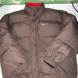 Nike brun puffer jacka - BUGIVNING avslutas onsdag 20:00 Jättesnygg jacka från Vintage Nike. FRI FRAKT!!!säljer då jag köpt en i samma modell som passar mig bättre  Köpt på en vintagesida men liite för kort för mig i ärmarna, dvs passar den både killar och tjejer som är runt 175 och kortare beroende på hur oversized man vill ha den. NUVARANDE BUD: 1450, buda gärna över med 50 kr :) bud är bindande, byten går utmärkt 