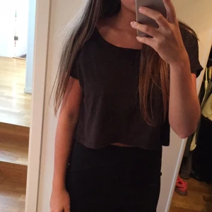  - Kort topp i en mörkgrå nyans. Nyskick. Ett mockaliknande tyg framtill. Väldigt skön. 