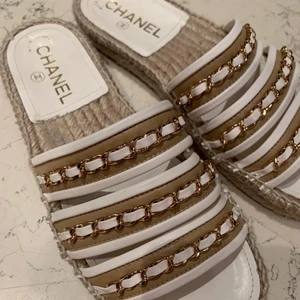 Chanel slippers i storlek 36 - Snygga beige Chanel slippers i storlek 36 med  guldkedja/vit detaljer, köptes i somras matchar till allt, 