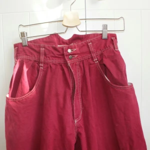 Knallröda high-waisted 80-talsbyxor - Snygga widecut 80-tals byxor!! Köpta på en loppis, äkta 80-tal alltså. Färgen måste ses i verkligheten, en blandning mellan knallröd och cerise-rosa ❤ I ett skönt jeans-aktigt material. High-waisted och ganska små i midjan, knäpps med två knappar och en dragkedja. Kmr till användning för sällan nuförtiden. Skriv om du har några frågor! Möts upp i Sthlm innerstad. 