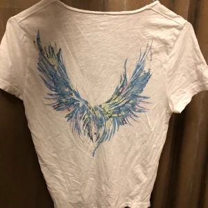 Zadig & Voltaire tröja - Vit t-shirt från zadig i storlek S med fint tryck på ryggen. Säljer den för att jag inte använder den längre. 