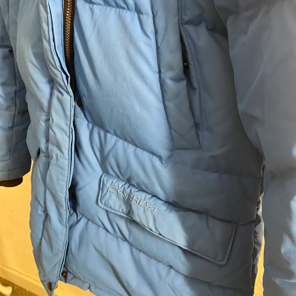Tjock blå vinterjacka med fyra fickor framtill, två innerfickor och en ficka för hörlurar. Den har samt en elastisk mudd med tumhål i ärmsluten. Perfekt till en kall vinterdag. Storlek 38 och priset för 300kr💖. Jackor.