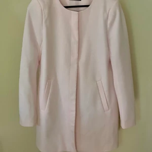 Kappa - Kappa i ljusrosa, bilden är inte rättvis med färgen. Storlek Medium. Rundad krage, med knappt från kragen och ner. Ganska rak modell. Struktur i tyget. Köparen står för ev. Frakt. 