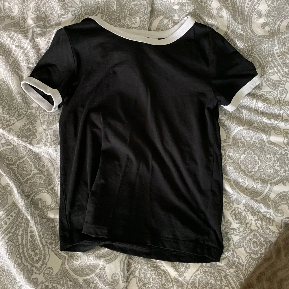 En svart t-shirt med vita detaljer från HM i storleken xs. Använd ett par ggr men är i ett bra skick ändå. 50kr + frakten 👍🏽. T-shirts.