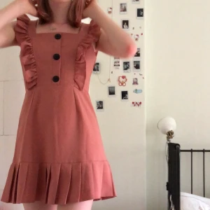 Rosa klänning - Jättefin klänning som bara är använd typ en gång! Köpt i Vietnam och är onesize. Jag på bilden är oftast en strl xs och 170 cm lång. Tror den passar upp till en liten medium. Köpt för typ 300 kr tror jag.;)  Frakt tillkommer. Fråga gärna om fler bilder eller annan info om den! 💕💕💕