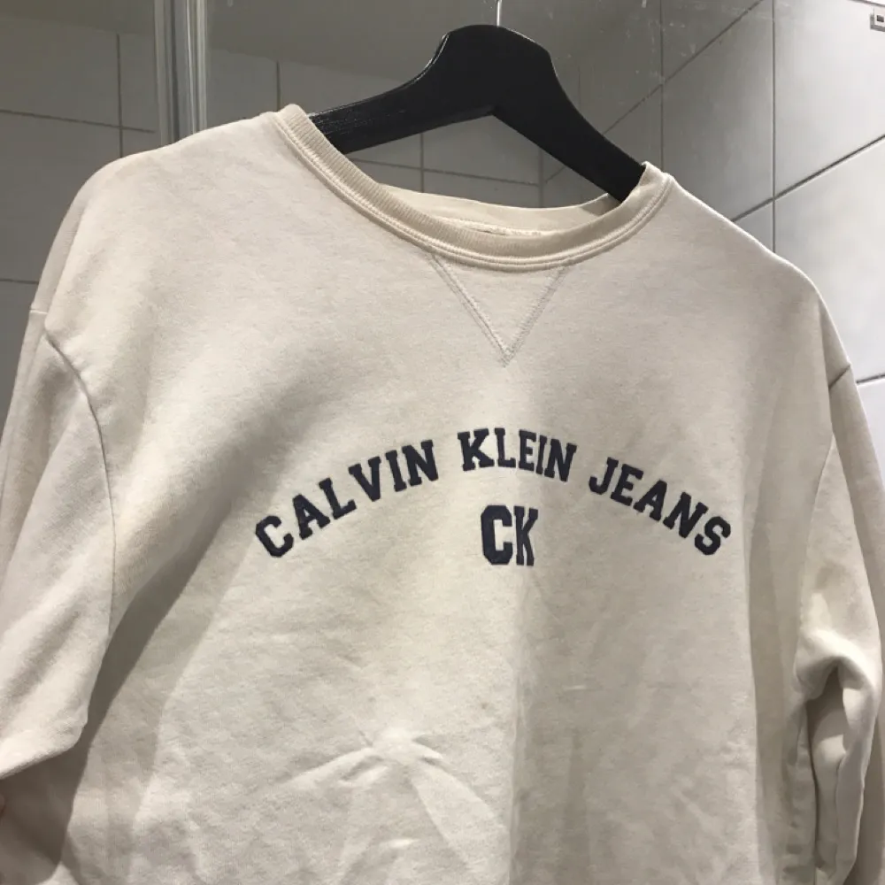 Retro Calvin Klein sweater.  Off white med marinblå text. Något nopprig på insidan men helt felfri utifrån.  Kan mötas upp i Stockholm, annars står köparen för frakten! :) . Hoodies.