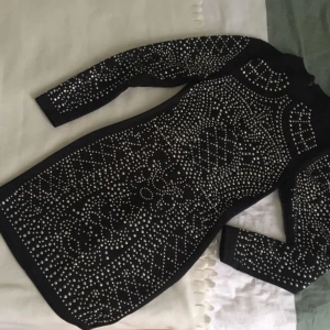  - Jättefin klänning med paljettdekoration framtill som passar xs-s. Dragkedja o knappar baktill