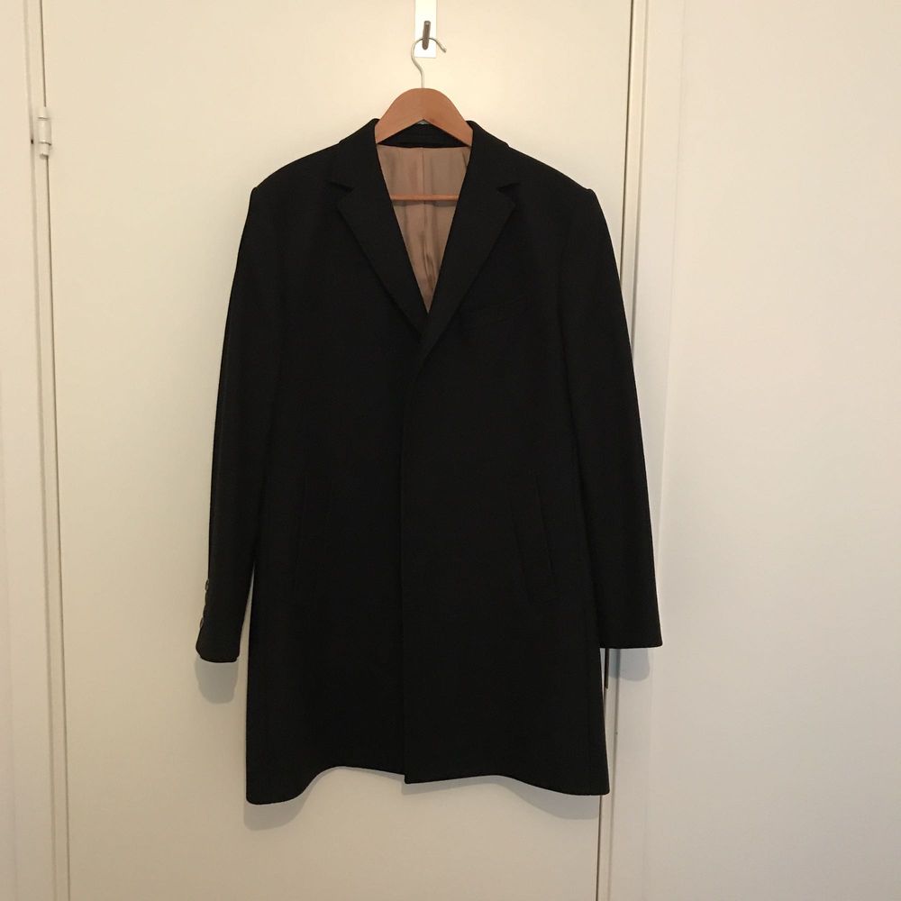 Stilren svart ull rock från J.Lindeberg, 80% ull 20% polyamid. Tidlös klassiker som funnits med i deras sortiment ett par år nu, denna med ljust innerfoder, extra innerficka (3 totalt) och snygg kant stickning runt om. Sparsamt använd och i mycket gott skick. Obs ärmarna är något kortade, min längd strax över 170 Finns att se och prova Järlasjö Nacka. Jackor.