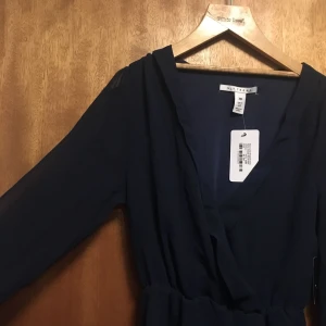  - Kort marinblå klänning! Armarna är transparenta medan resten är dubbelt tyg. Aldrig använd, från Nelly trend. 