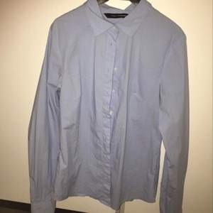 Figursydd ljusblå skjorta i stretchigt tyg, storlek 34. Köpare står för frakt 