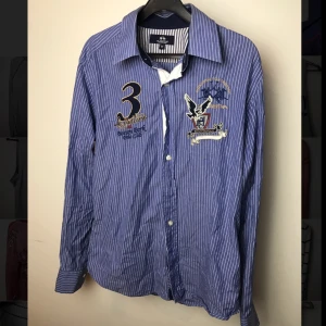 - Fräsig skjorta från La Martina, påsydda märken på bröstet. Nypris: ca 1000 kr Hör av dig för fler bilder eller frågor :)