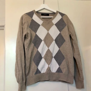Beige argyle tröja  - Vintage argyle pullover i beige, vit och grå; perfekt för hösten! I herrstorlek S men passar fint som oversize på XS/S. Köpt secondhand men i perfekt skick :) Spårbar frakt tillkommer på 60kr!💓 säljer även tenniskjolen!