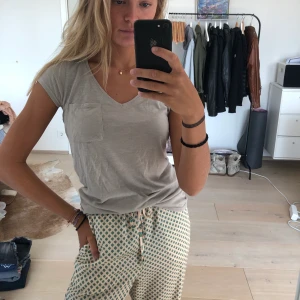 Plain T-shirt - Skön beige T-shirt med ficka. Aldrig använd.