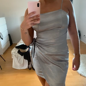 Silvrig festklänning  - En snygg festklänning i ett silvrigt tyg som passar perfekt nu till nyår eller andra festliga tillfällen. Materialet är lite silkesaktigt skulle jag säga och inte speciellt töjbart. Passar xs/s. Frakt ingår💜